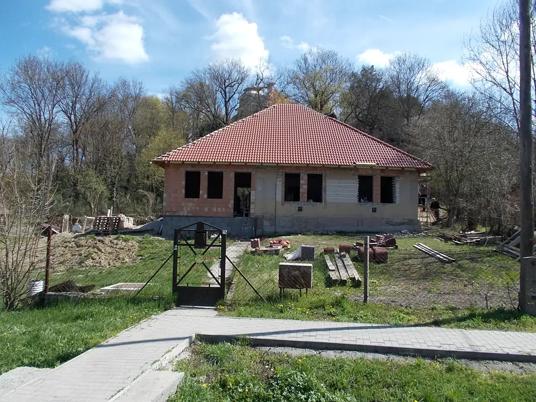 Obiteljska kuća u završnoj fazi gradnje — žbukanje fasade i postavljena krovna konstrukcija (demo prikaz, Mađarska)