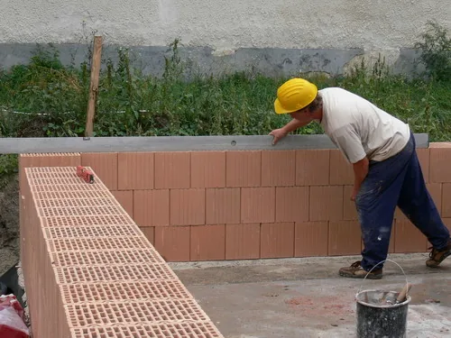 Radnik slaže blokove opeke na gradilištu